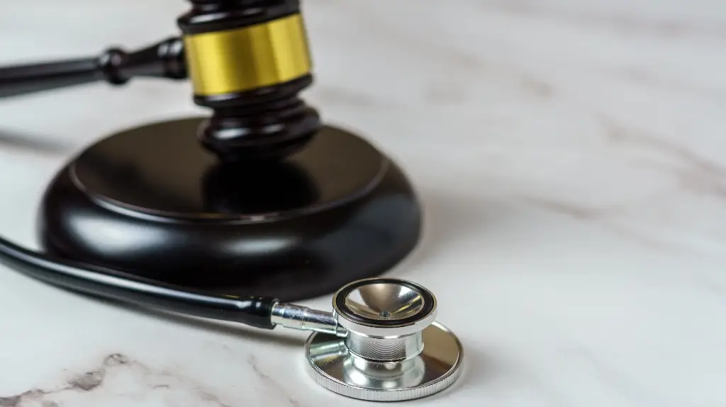 Gavel and stethoscope on a marble surface representing legal and medical fields